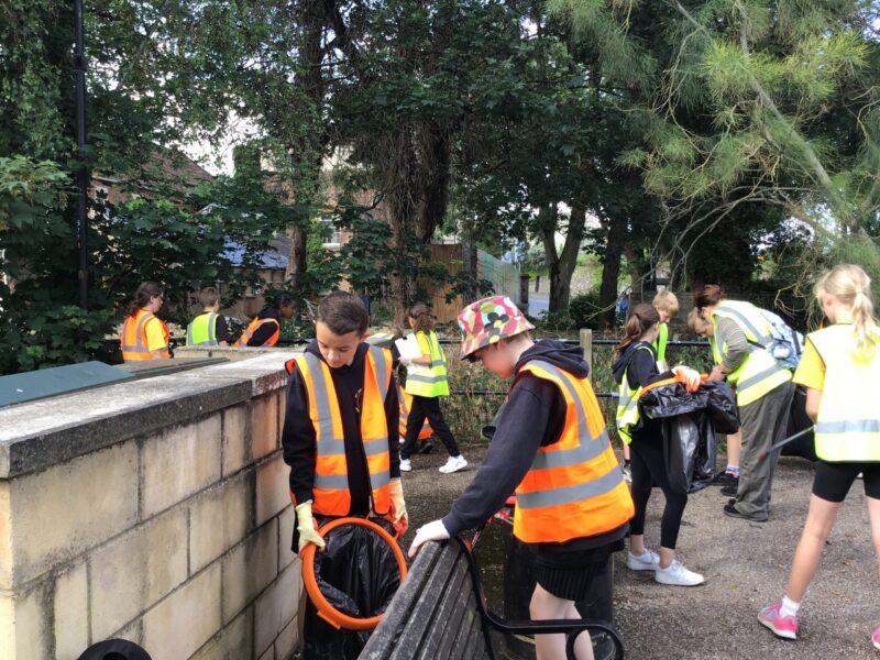 students litter picking with high vis