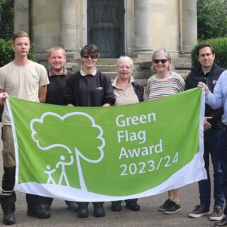 green flag award flag being held by park staff